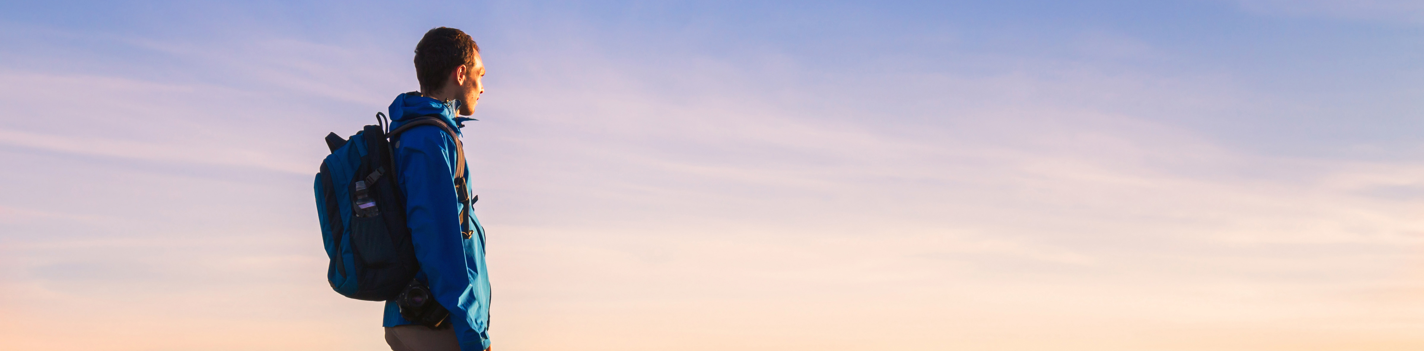 man standing on mountain at sunset